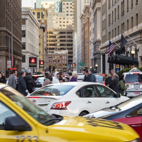 Taxis, an Uber, other cars, and people walking in congested downtown San Francisco