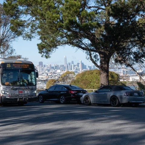 Muni bus drives past cityscape