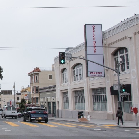 View of Arguello Boulevard with vehicles, pedestrians, and buildings