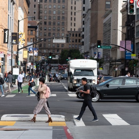 Pedestrians and cars crossing an intersection on Howard Street.