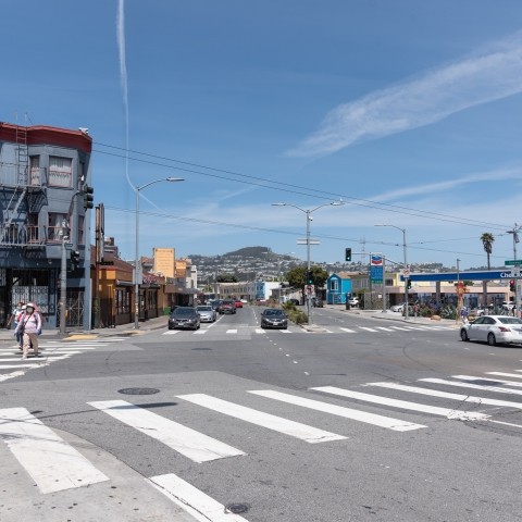 View of the Mission Street and Geneva Avenue intersection with cars and pedestrians.