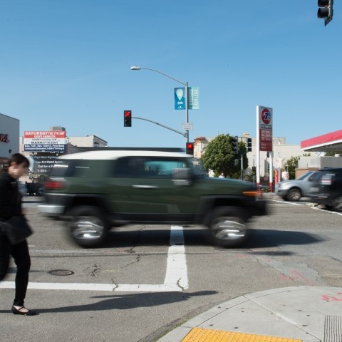 Pedestrian and cars crossing an intersection.