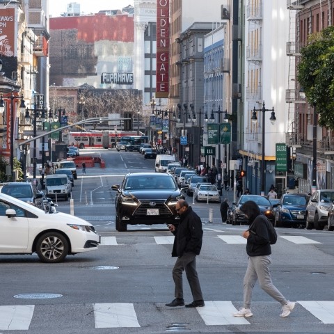 People and cars crossing an intersection on Taylor Street.