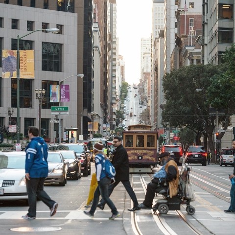 Pedestrians and wheelchair user crossing street in San Francisco