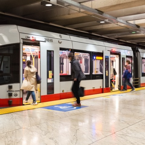 People boarding Muni metro train in underground station 