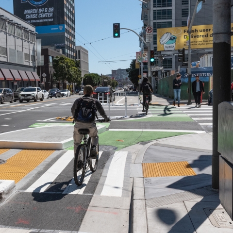 Cyclist riding through protected intersection at 5th and Howard Street