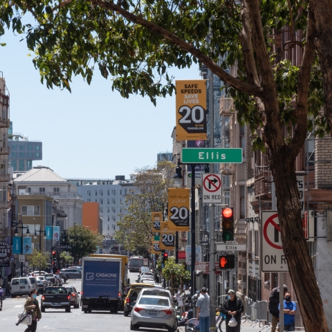 Ellis Street with Vision Zero signage and people on the sidewalk and cars on the road