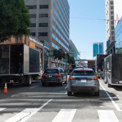 Commercial truck double parked in the downtown area. 