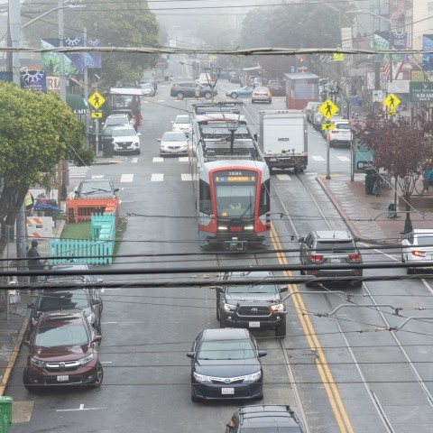 Overhead view of Muni light rail vehicle and vehicles along Irving Street