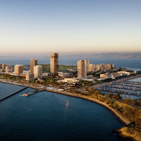 Rendered image of an island with buildings and a port in the nearby lagoon. There is a ferry pulling up to a dock in the foreground.  