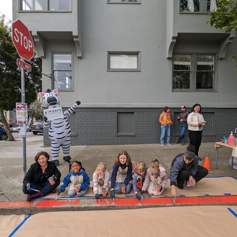 SFCTA Chair Melgar pictured with students and SFMTA staff painting a curb red to daylight it