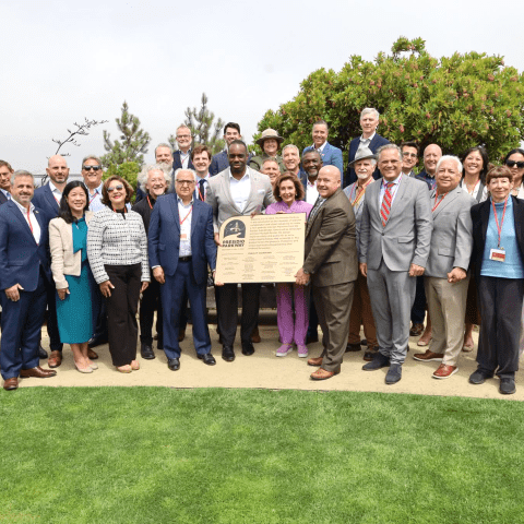 City officials, transportation officials and staff gathered with a plaque to celebrate 10 years of the Presidio Parkway