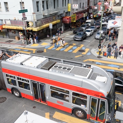 Overhead view of buses, cars, and people on the road in San Francisco's Chinatown