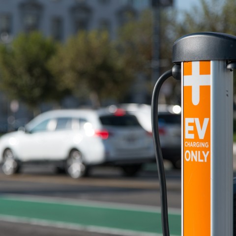 A curbside EV charger, orange pole with text that says "EV Charging Only" 