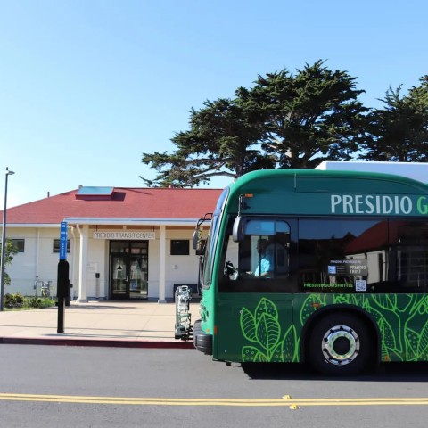 A Presidio GO battery electric bus is parked in front of the Presidio Transit Center.
