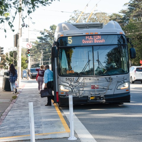 The 5 Fulton Muni bus is stopped at 8th Ave, letting people off