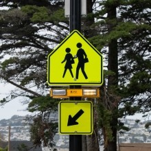 Reflective yellow crosswalk sign with pedestrian icons