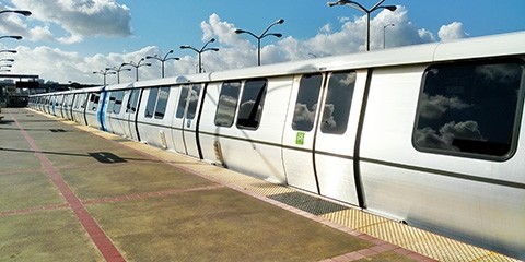A new BART train waits at a station. The train fills the frame from end to end